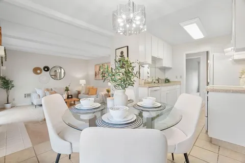 a dining room with furniture a chandelier and window