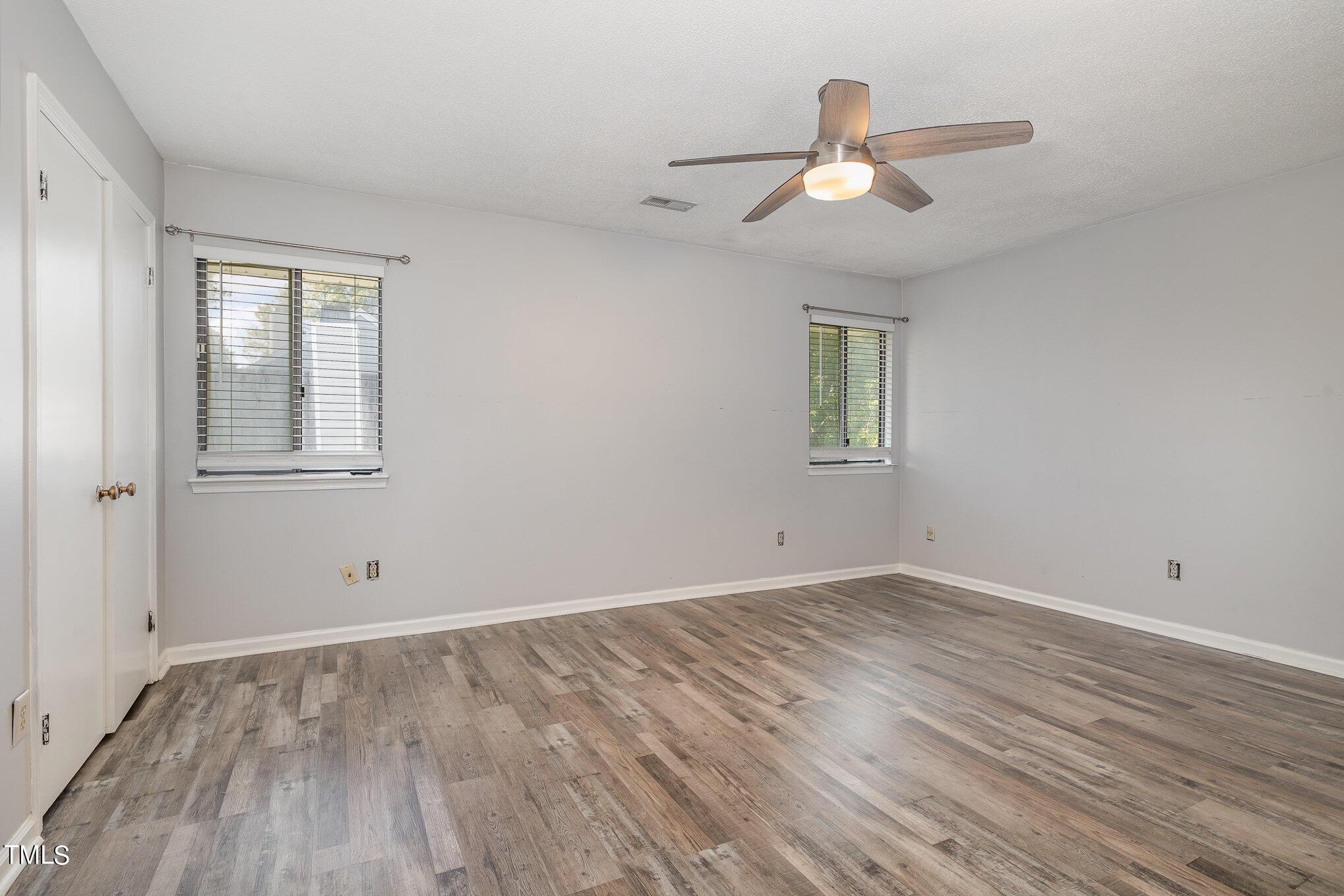 3702 San Pablo Drive Raleigh, NC 27616 - Photo 16 of 26 an empty room with wooden floor chandelier fan and windows