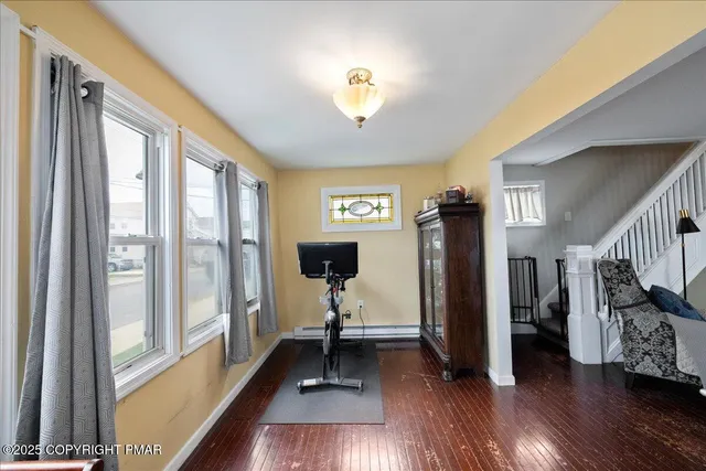 a view of a hallway with wooden floor and windows