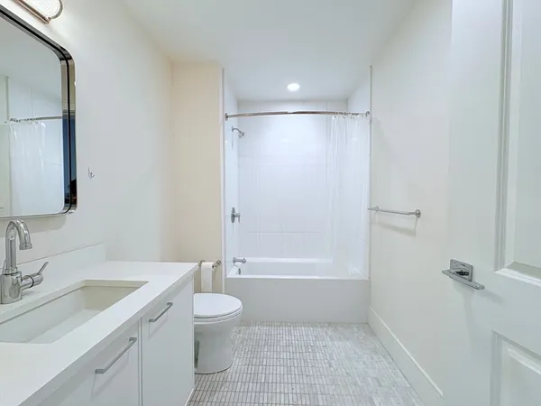a bathroom with a granite countertop sink a toilet and shower