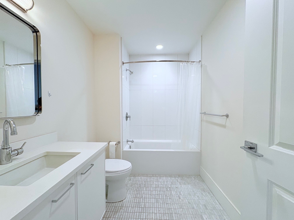 214 Market Street, Unit 405 Boston, MA 02135 - Photo 13 of 22 a bathroom with a granite countertop sink a toilet and shower