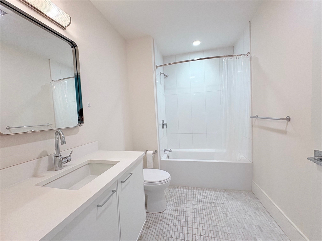 214 Market Street, Unit 405 Boston, MA 02135 - Photo 14 of 22 a bathroom with a sink a toilet and shower