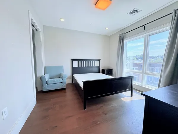 a bedroom with a bed and wooden floor
