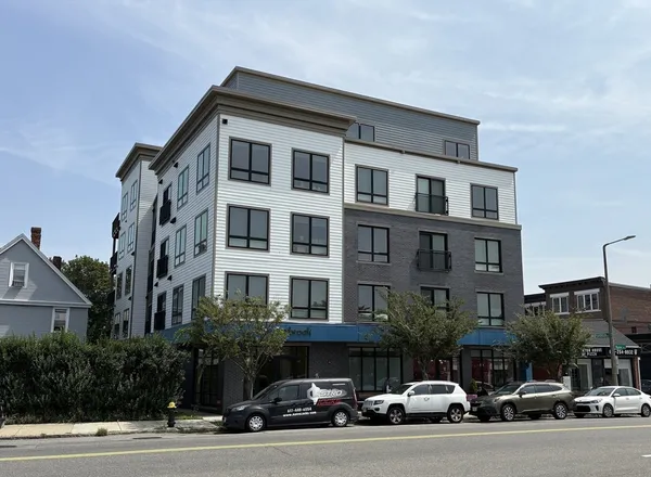 a couple of cars parked in front of a building