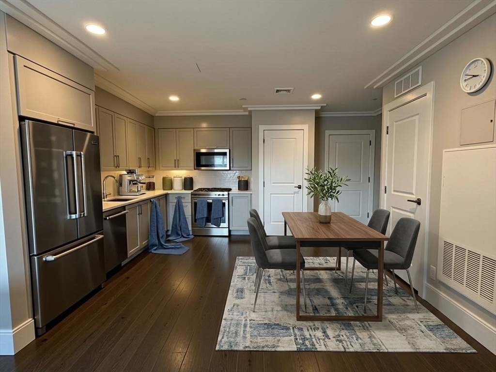214 Market Street, Unit 405 Boston, MA 02135 - Photo 3 of 22 a kitchen with stainless steel appliances kitchen island granite countertop a refrigerator a stove a sink a dining table and chairs