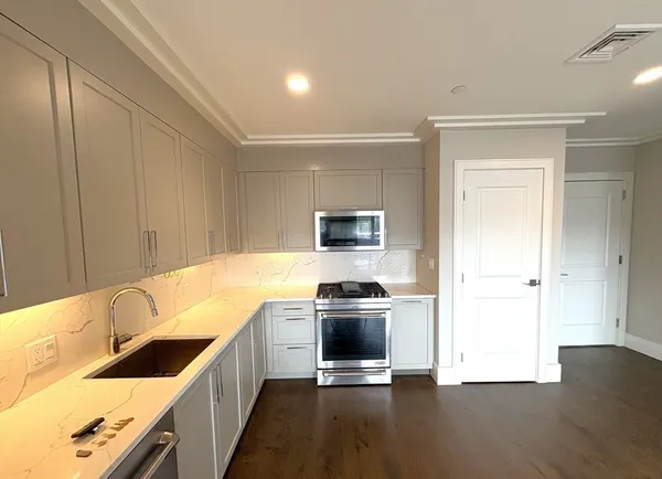 a kitchen with a stove a sink and a refrigerator