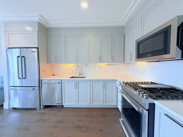 a kitchen with stainless steel appliances granite countertop a refrigerator stove and microwave
