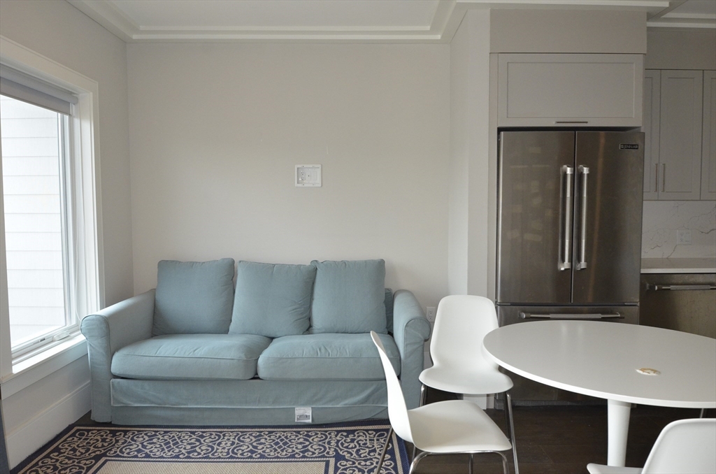 214 Market Street, Unit 405 Boston, MA 02135 - Photo 8 of 22 a living room with furniture and a window