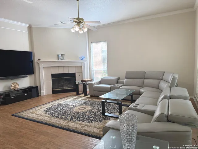 a dining room with wooden floor a chandelier a glass table and chairs