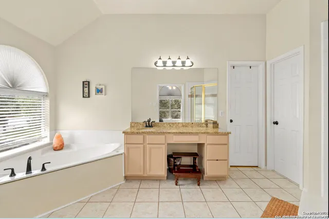 a en suite bathroom with a granite countertop tub and a sink