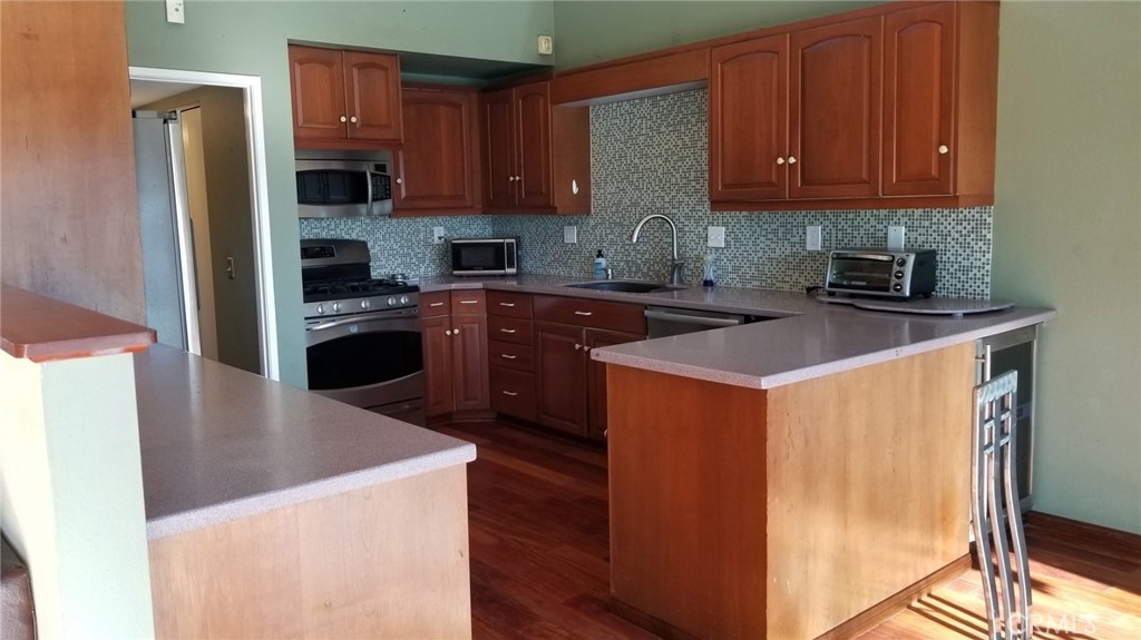 4640 Eastbourne Bay Oxnard, CA 93035 - Photo 6 of 16 a kitchen with stainless steel appliances granite countertop a stove a refrigerator a sink and a microwave