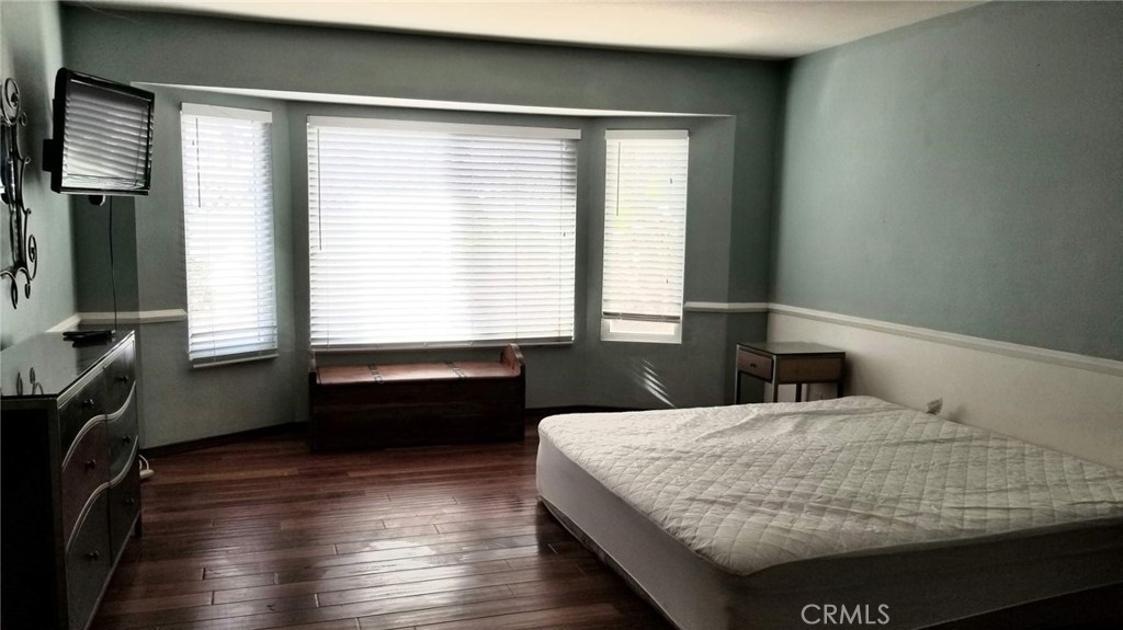 4640 Eastbourne Bay Oxnard, CA 93035 - Photo 8 of 16 a bedroom with a bed and wooden floor