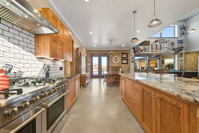 a living room with furniture kitchen view and a large window