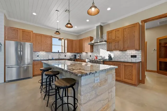 a large kitchen with stainless steel appliances granite countertop a lot of counter space and a sink