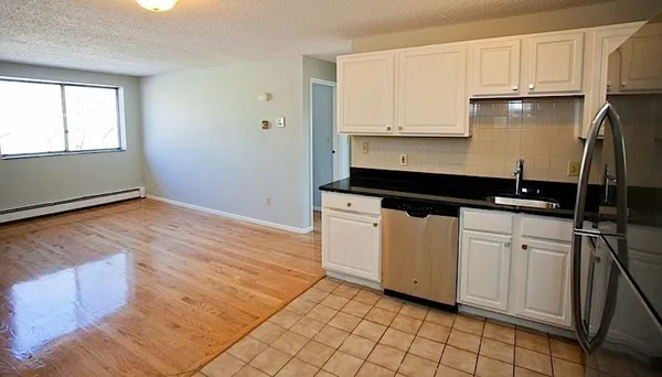 a kitchen with granite countertop white cabinets and black appliances