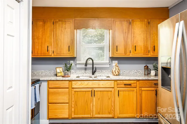 a kitchen with stainless steel appliances granite countertop a sink and a window