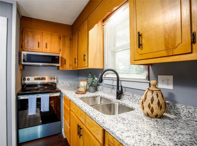 a kitchen with granite countertop a sink and a stove