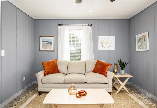 a blue couch sitting in a living room with a couch and a potted plant