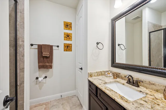 a bathroom with a granite countertop sink and a mirror