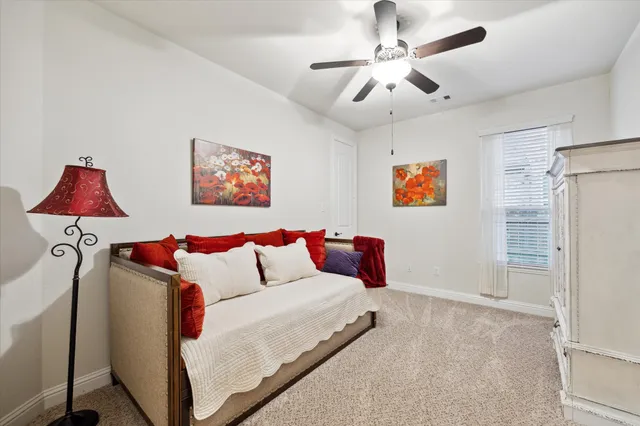 a bedroom with furniture and a ceiling fan