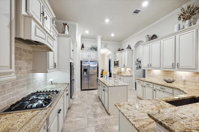 a kitchen with stainless steel appliances kitchen island granite countertop a sink and cabinets