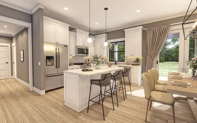 a kitchen with stainless steel appliances kitchen island granite countertop a refrigerator a stove a oven and white cabinets with wooden floors