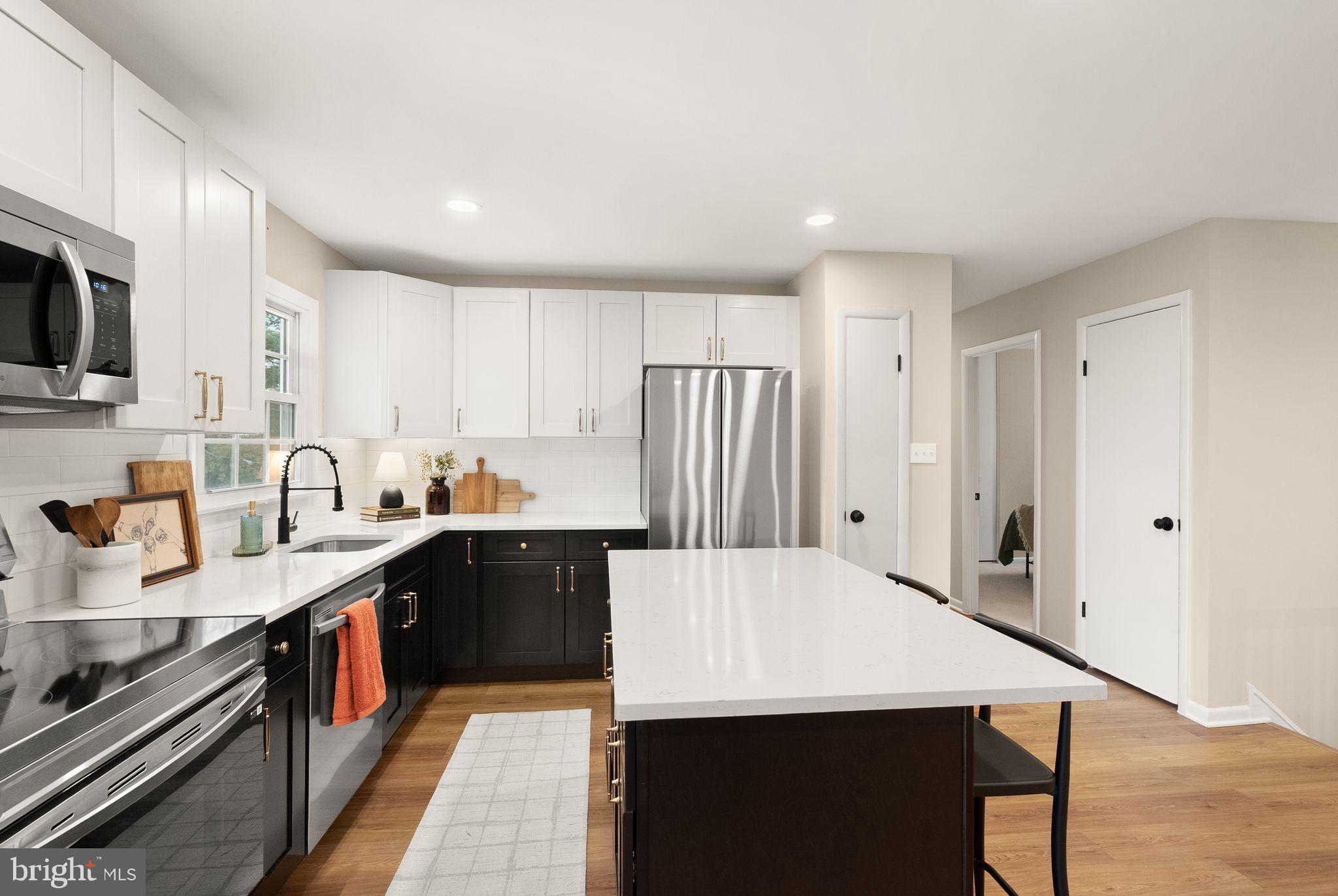 12412 Needle Drive Clarksburg, MD 20871 - Photo 14 of 51 a kitchen with stainless steel appliances a refrigerator a sink a stove oven and white cabinets