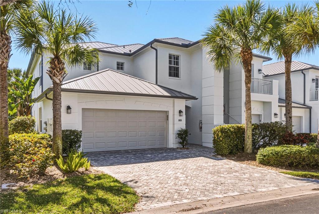 9041 Whimbrel Watch Lane, Unit 101 Naples, FL 34109 - Photo 1 of 34 View of front of property with a standing seam roof, decorative driveway, and a garage