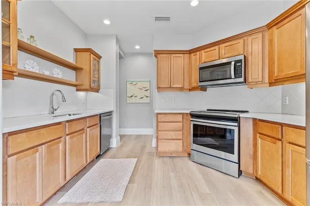 a kitchen with stainless steel appliances granite countertop a stove a sink and a microwave