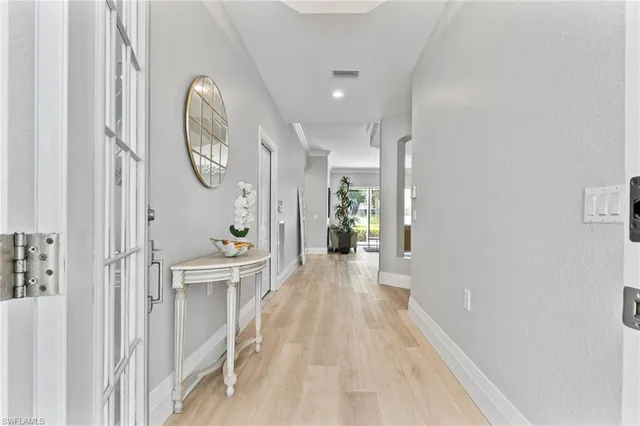 view of a hallway with wooden floor and a living room