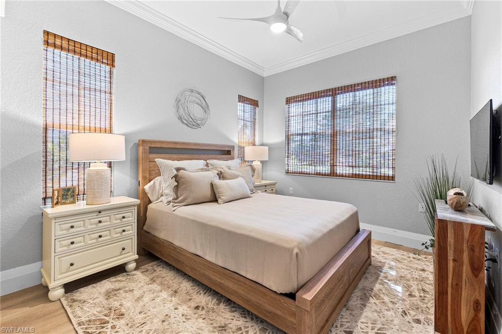 9041 Whimbrel Watch Lane, Unit 101 Naples, FL 34109 - Photo 23 of 34 Bedroom with ornamental molding, a ceiling fan, and a textured wall