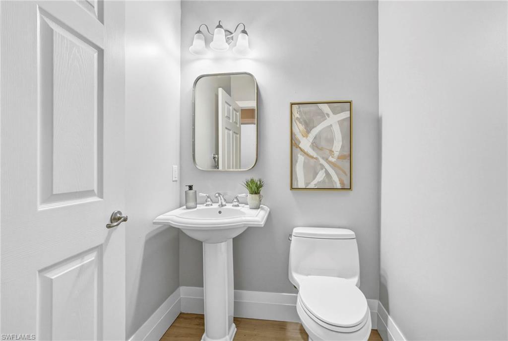 9041 Whimbrel Watch Lane, Unit 101 Naples, FL 34109 - Photo 26 of 34 Bathroom featuring toilet and wood finished floors
