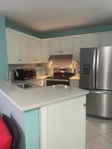 a kitchen with a refrigerator a stove a microwave and cabinets