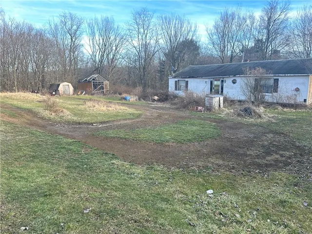 a view of a house with backyard and sitting area