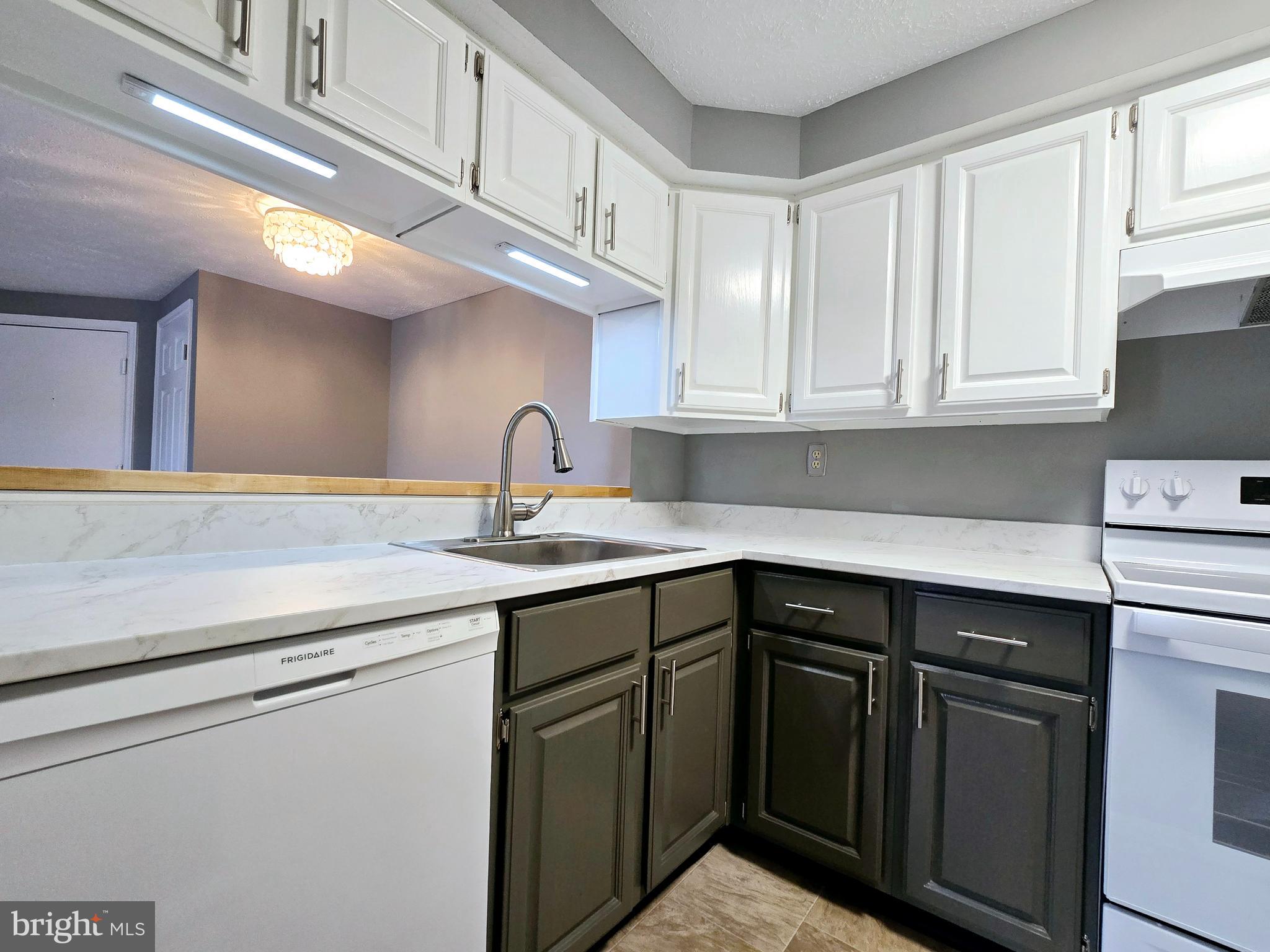 821 Stratford Way, Unit H Frederick, MD 21701 - Photo 14 of 45 a kitchen with stainless steel appliances granite countertop a sink and dishwasher with white cabinets