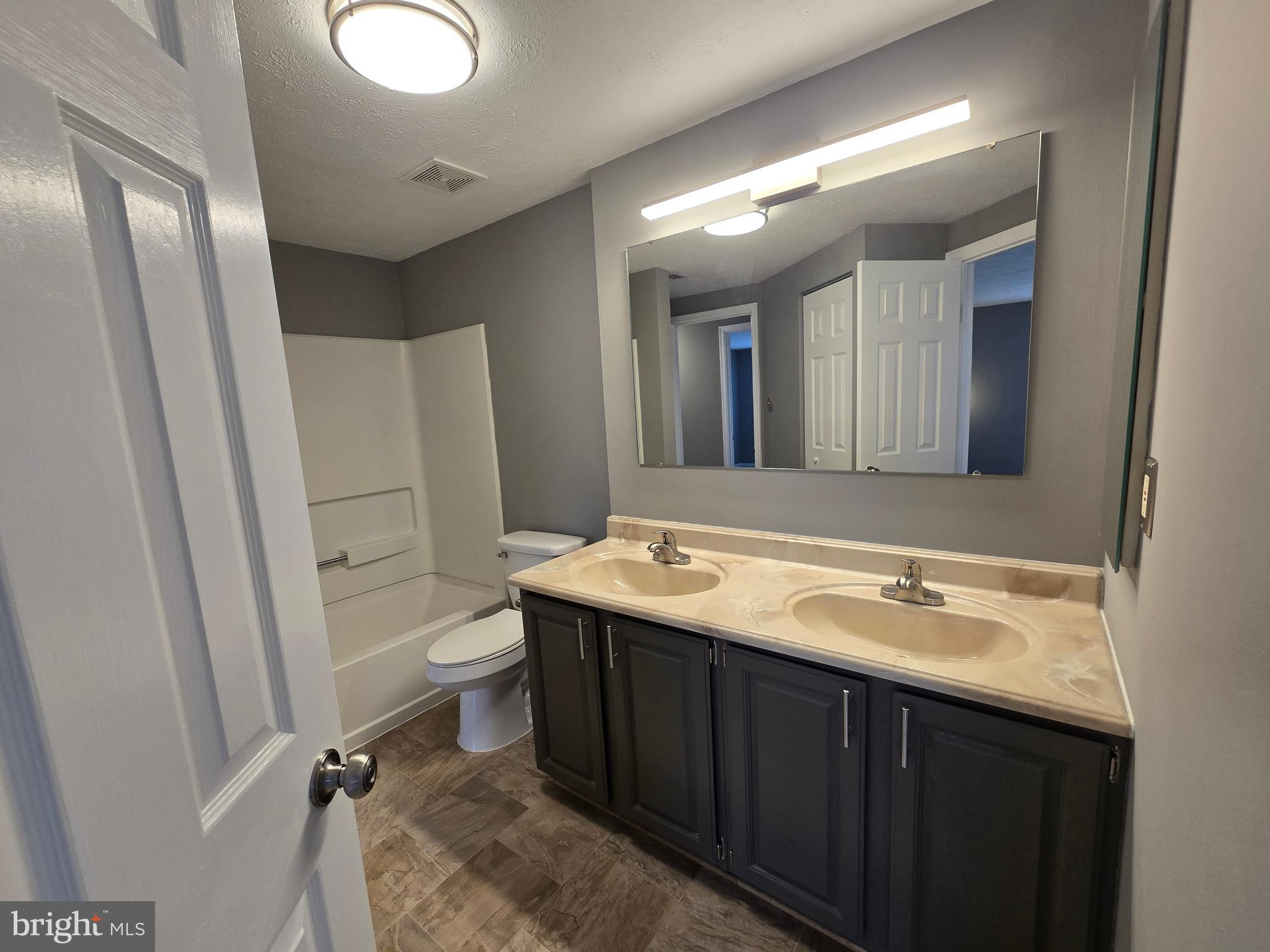 821 Stratford Way, Unit H Frederick, MD 21701 - Photo 34 of 45 a bathroom with a double vanity sink toilet and mirror