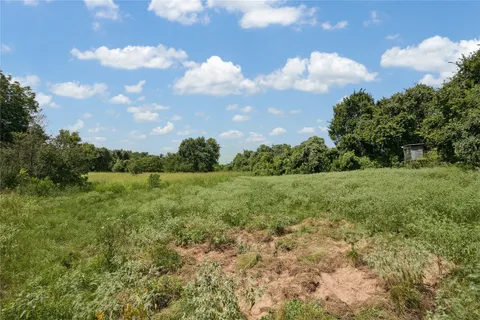 a view of a green field with wooden fence