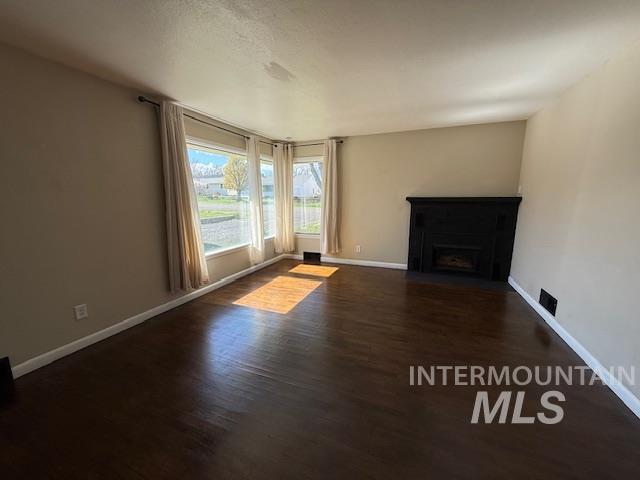 1139 Webster Street Clarkston, WA 99403 - Photo 8 of 34 Unfurnished living room featuring a fireplace with flush hearth and dark wood-style flooring