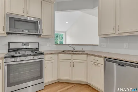 a kitchen with white cabinets and appliances