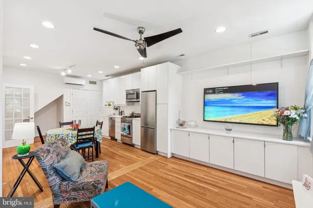 a living room with furniture kitchen view and a large window