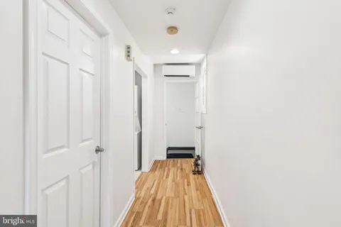 a view of a hallway with wooden floor and entryway