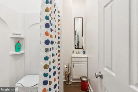 a bathroom with a toilet and a shower curtain