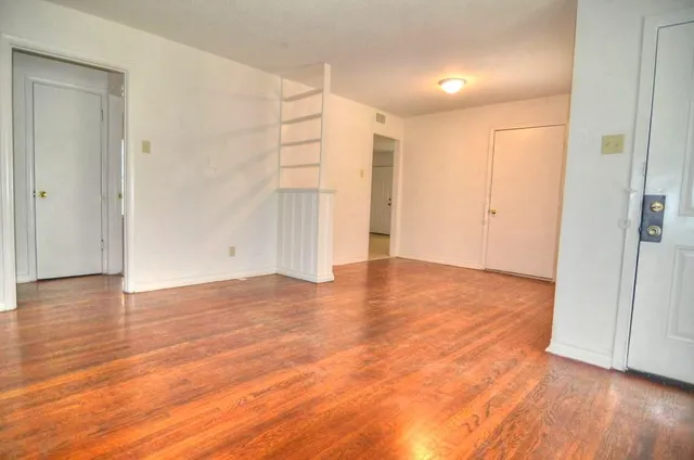 a view of an empty room with wooden floor