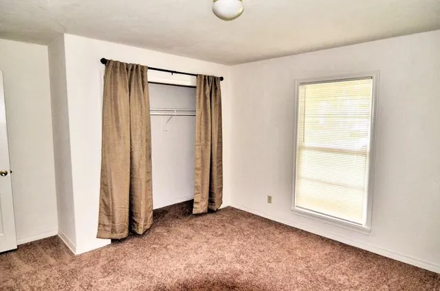 an empty room with windows and closet