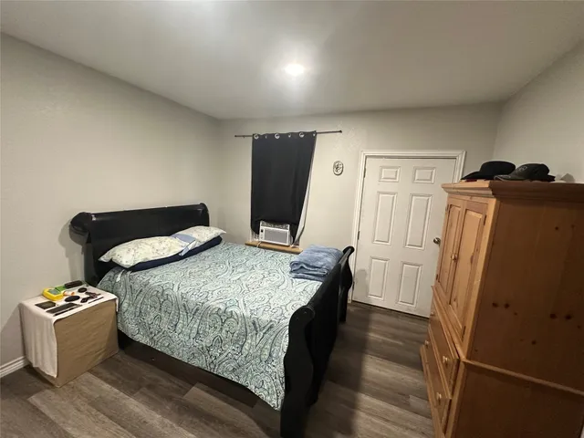 a bedroom with bed and wooden floor