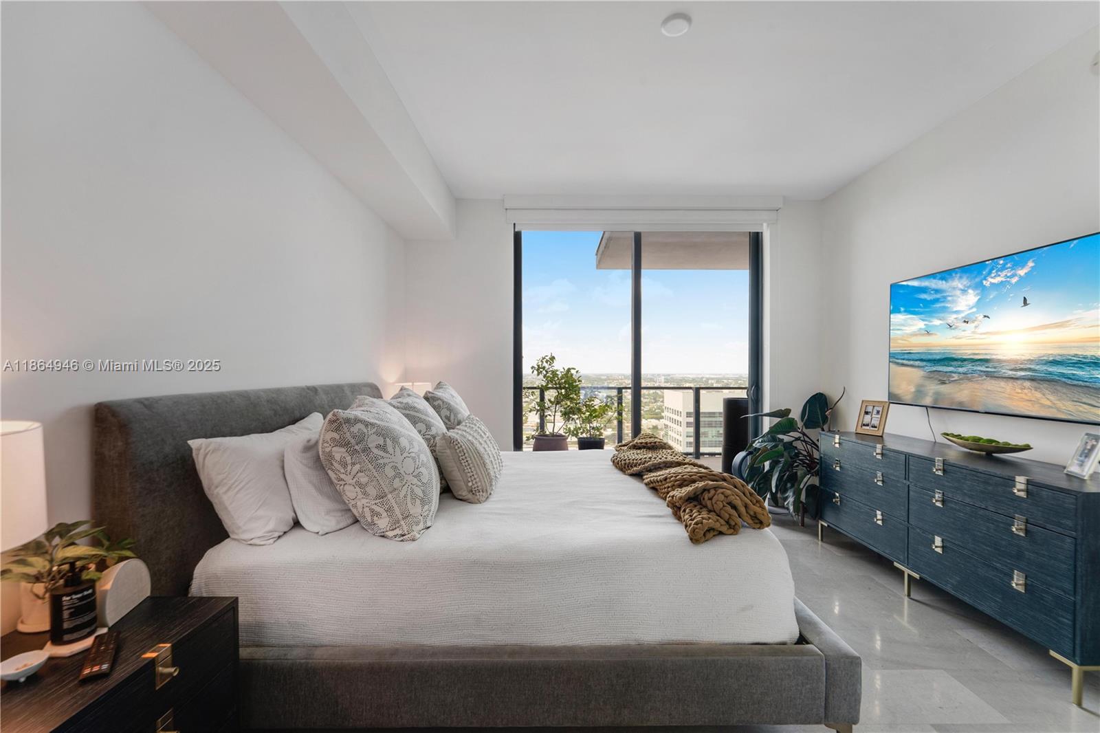 88 Southwest 7th Street, Unit 2910 Miami, FL 33130 - Photo 12 of 22 a bedroom with a bed and large windows