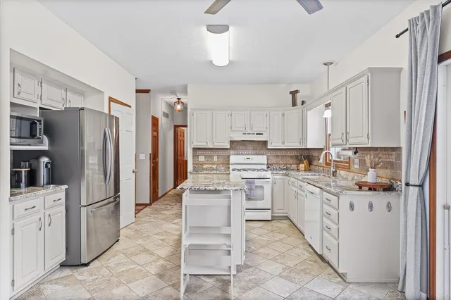 a kitchen with stainless steel appliances granite countertop a sink stove and cabinets