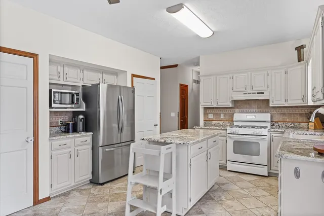 a kitchen with cabinets stainless steel appliances and a counter space