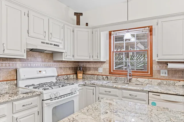 a living room with furniture a fireplace and a chandelier
