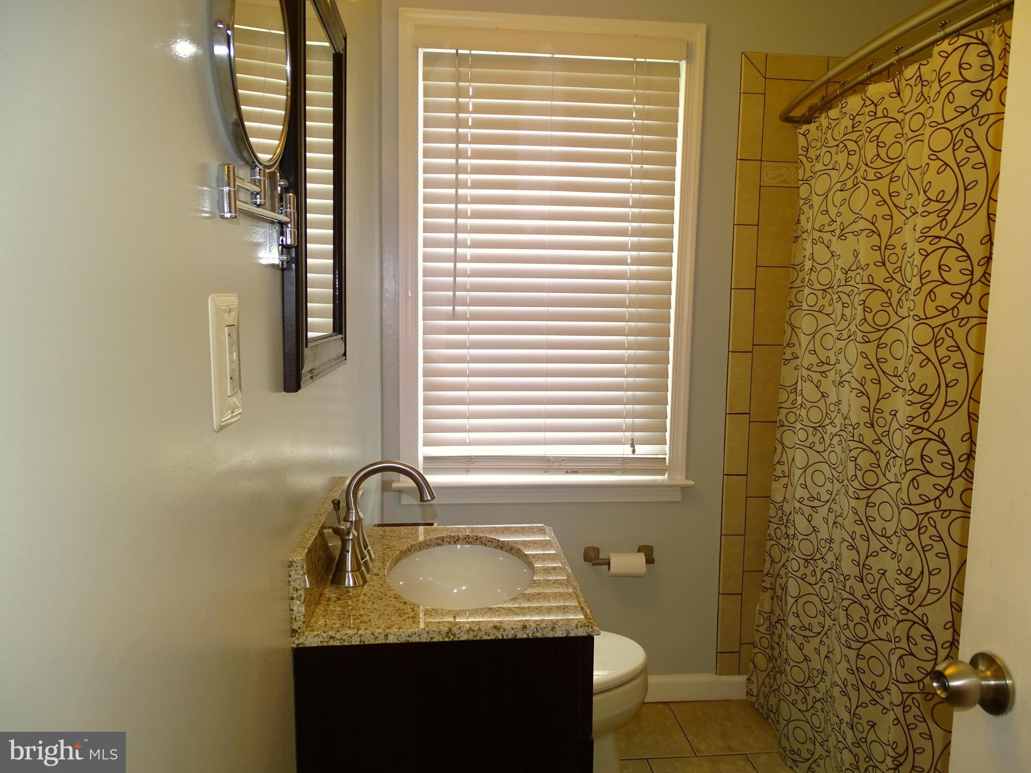 6106 Mt Ridge Road Catonsville, MD 21228 - Photo 16 of 30 a bathroom with a granite countertop sink and a mirror